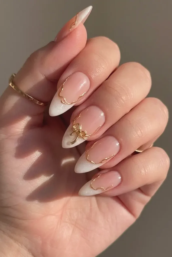 French Nails mit feinen goldenen Linien und kleinen Perlendetails, Hand hält Hochzeitseinladung