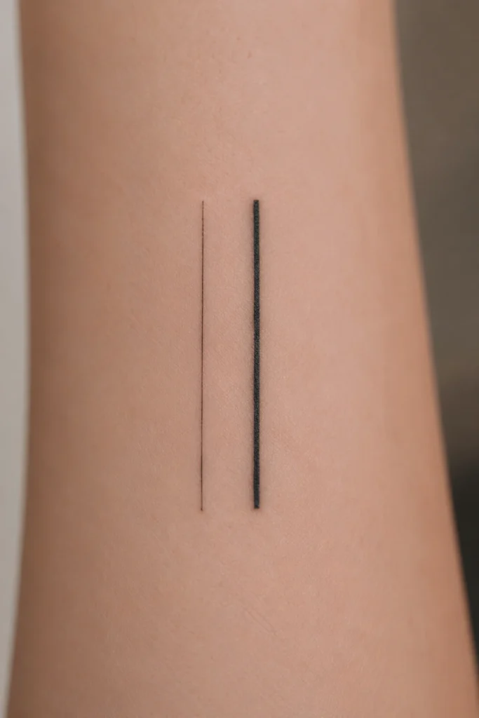 Detailansicht und Vergleich einer feinen Single-Needle-Tattoo-Linie mit einer Standard-Tattoo-Linie auf heller Haut bei sauberer Studiobeleuchtung.